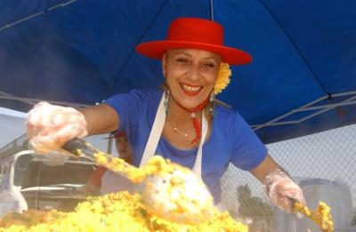 Cuisinier espagnol prépare paella sur un étal du marché de l'agriculteur