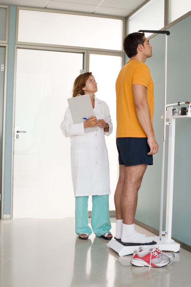 Un homme's height is measured in a medical center.