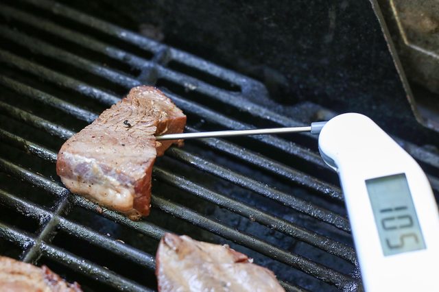 thermomètre à viande dans les steaks sur le gril.