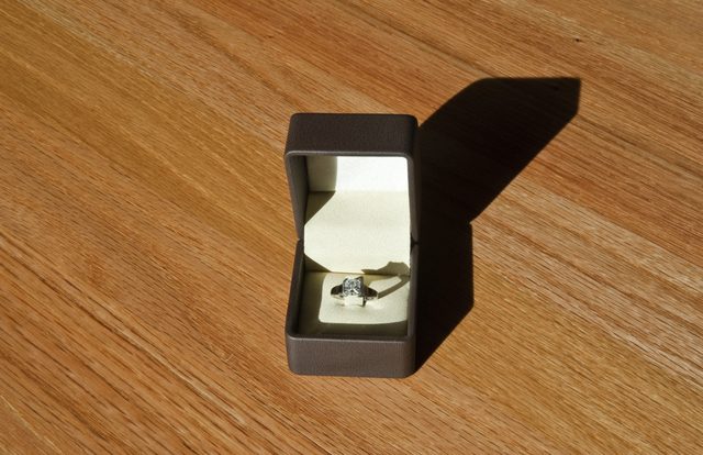Un anneau dans une boîte en plein soleil sur un bureau.