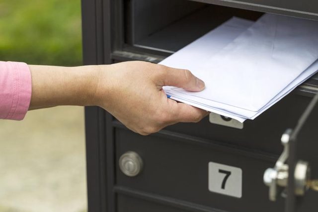 Femme recevoir du courrier de la boîte aux lettres