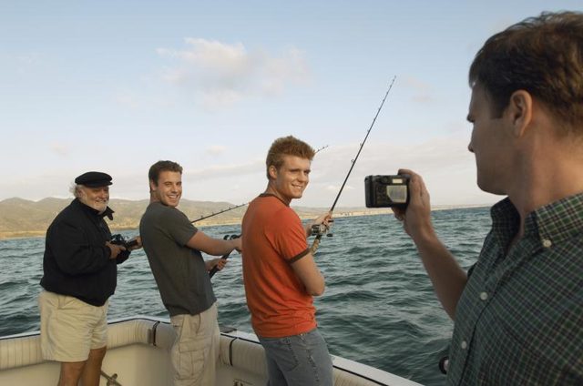 Un groupe d'amis prend une photo tandis que la pêche sur un bateau.
