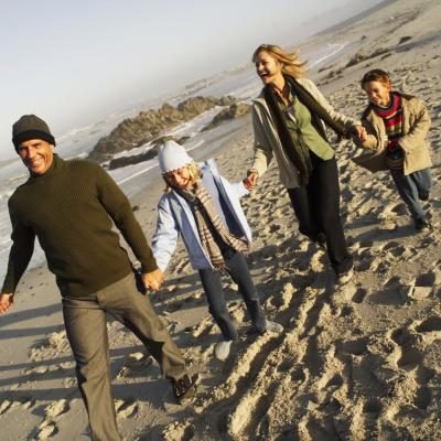 Famille à la plage portant des vêtements chauds
