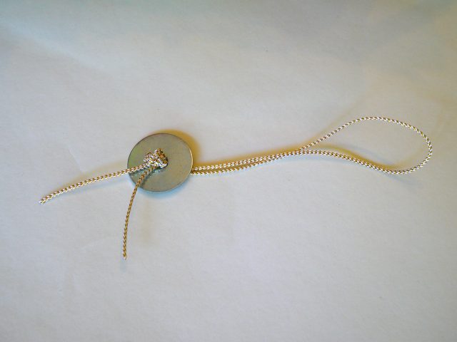 cordon de fil à travers la rondelle et sécurisé avec un nœud d'épaisseur.
